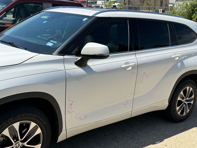 A silver toyota highlander is parked in a parking lot.