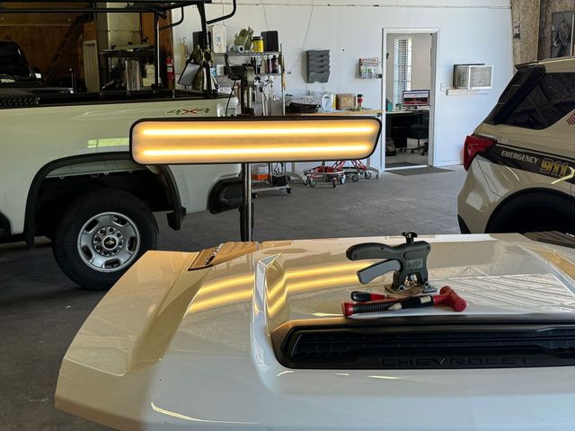 A white truck is being repaired in a garage