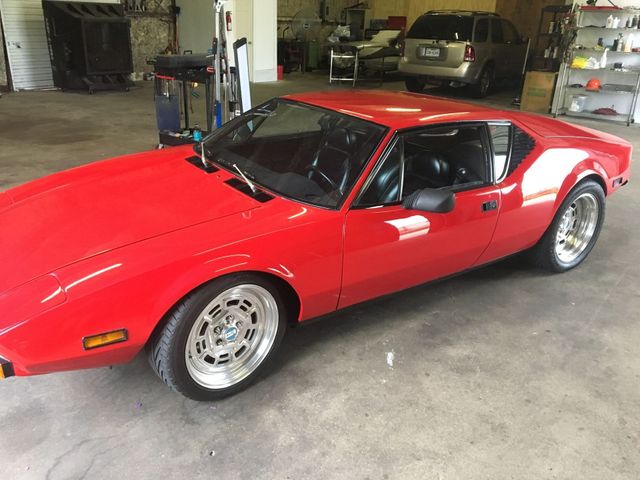 A red sports car is parked in a garage